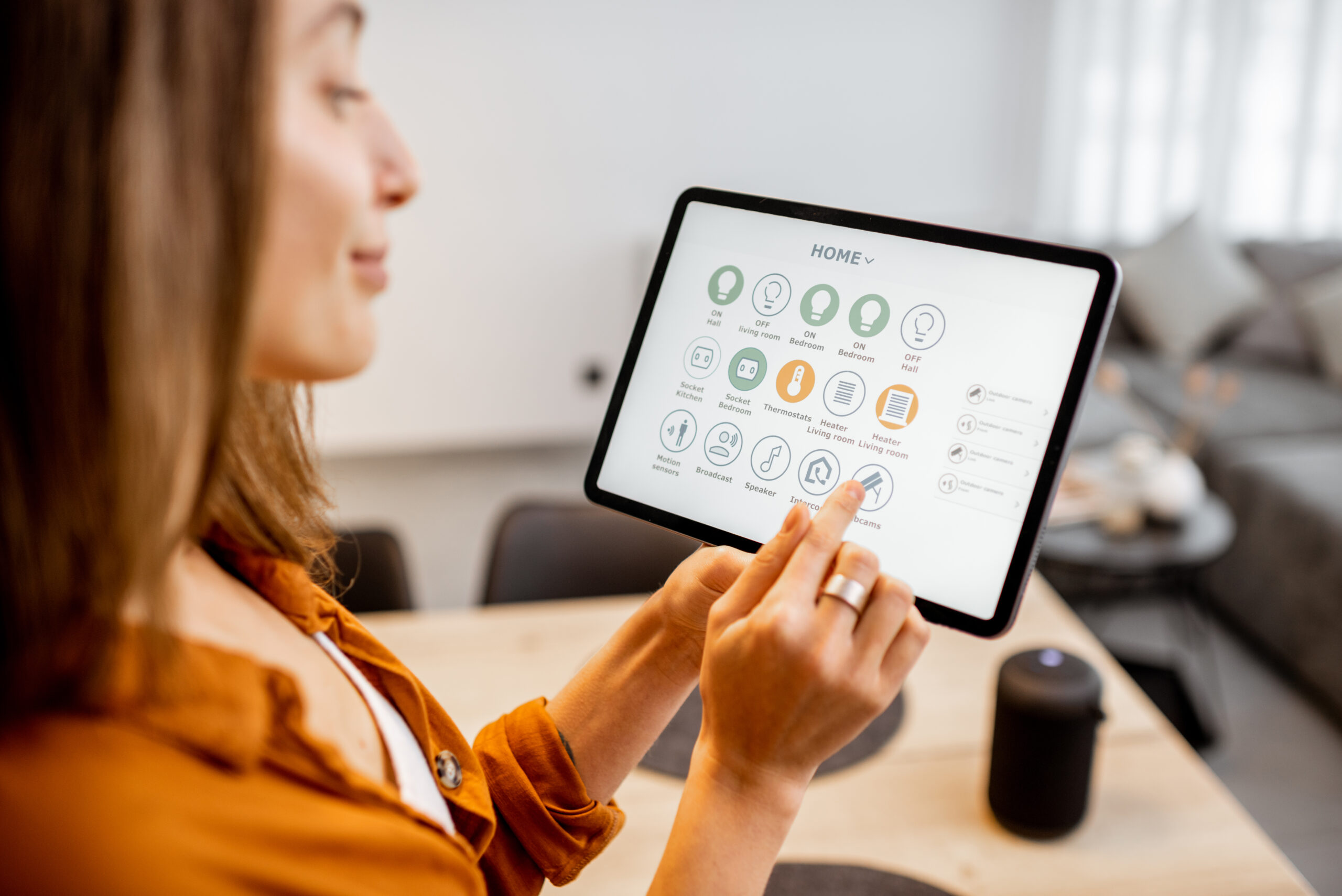 Eine junge Frau steuert ihr smart home über ein Tablet
