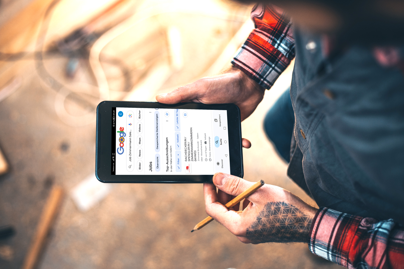 Ein Handwerker schaut sich auf seinem Smartphone Google for Jobs an