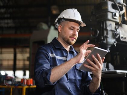 Ein Handwerker hat ein Tablet in der Hand und vergrößert gerade die Ansicht