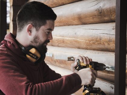 Ein junger Handwerker setzt eine Bohrmaschine an