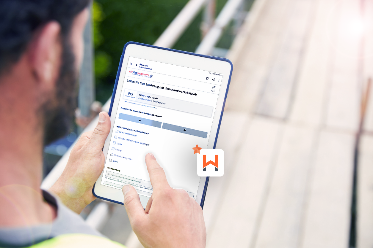 Ein Handwerker erfasst vor Ort beim Kunden eine Bewertung auf seinem Tablet
